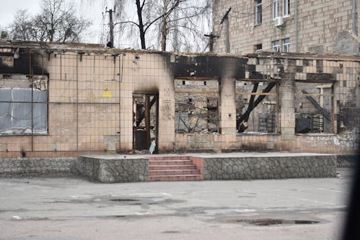Exterior view of a war-damaged building with destroyed facade and debris.